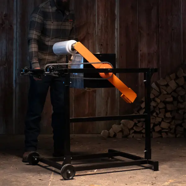 IronEmber Firewood Bundler being used to wrap firewood with shrink wrap, creating a neat and tightly secured bundle.